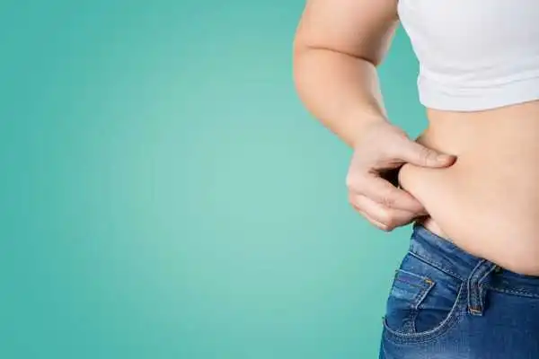 Image of woman pinching her love handles to show weight gain Taunton